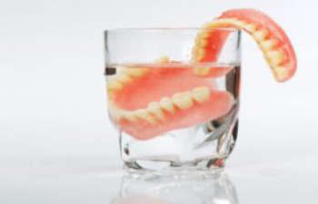 A denture set in a glass of water.