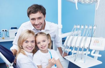 A family is posing for a photo in a dentist's office.