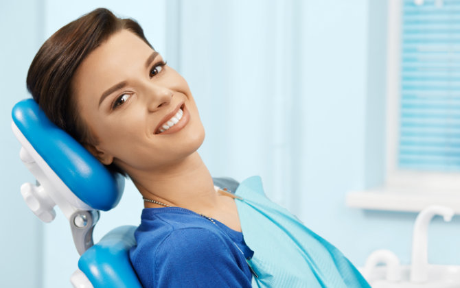 Relaxed happy woman in a dental chair showing beautiful teeth in her smile.