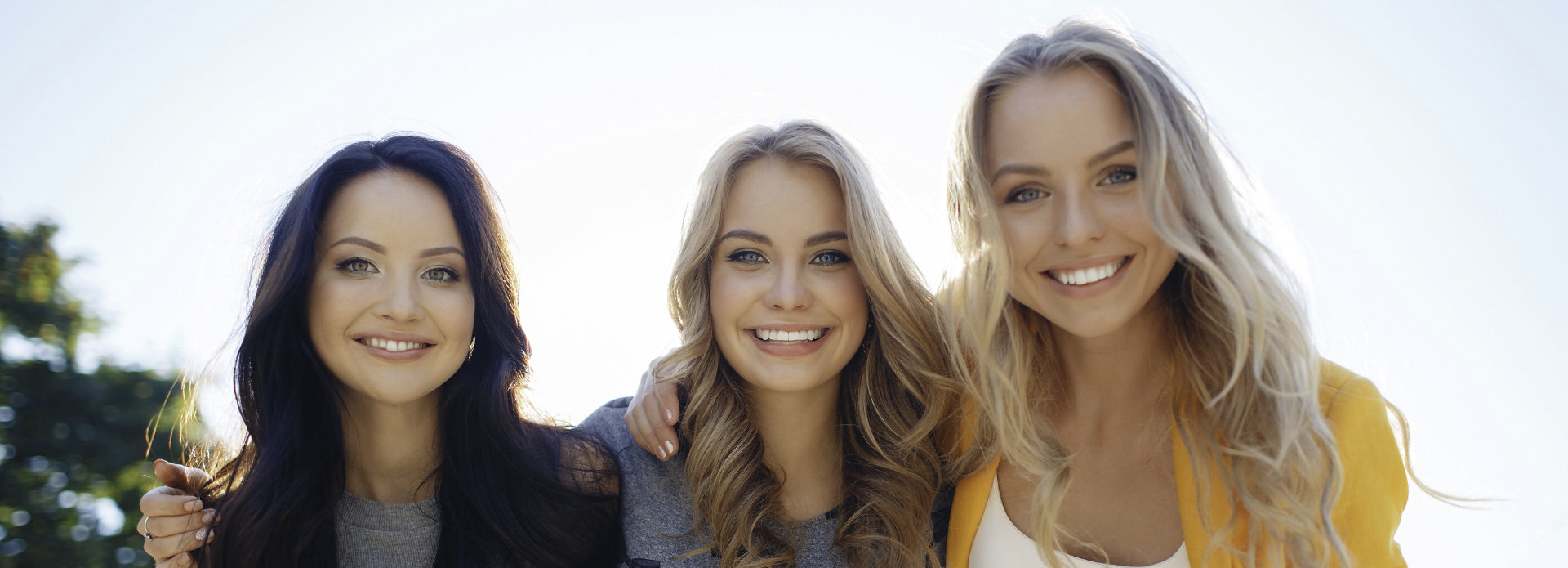 Three young women with perfect smiles.