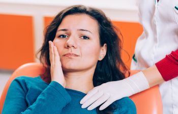 A woman is sitting in a dentist's chair.