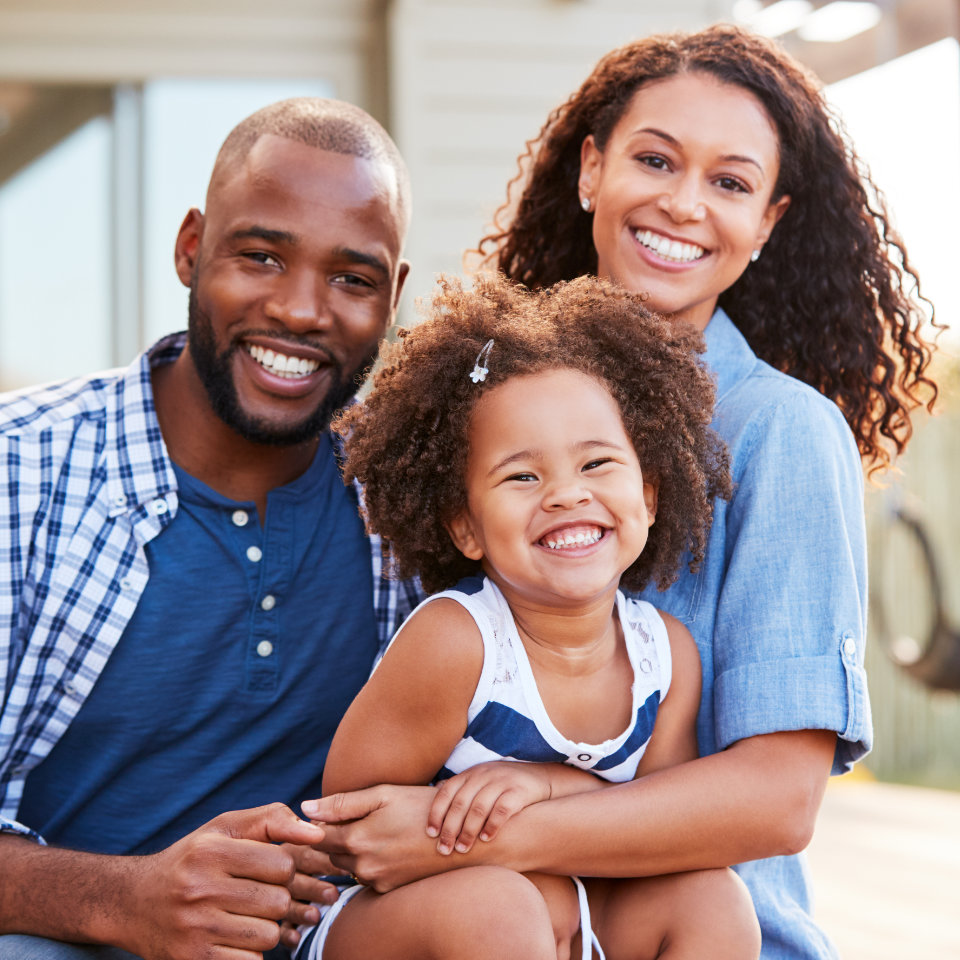 Happy African-American man and woman with their daughter.