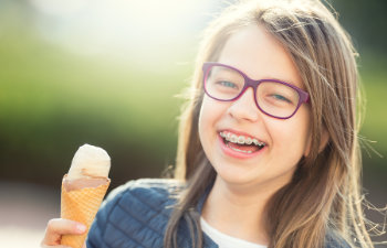 laughing girl with braces holds an ice cream