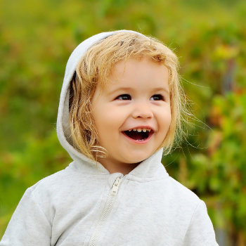 laughing child in a white hoodie